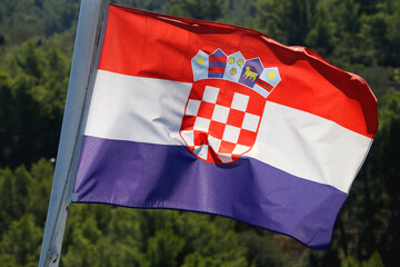 Flag of Croatia blowing in the wind. Forest in the background. Selective focus.