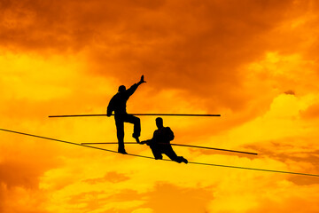 Wandering tightrope walker playing on yellow sky background. Silhouette of Equilibrist businessman...