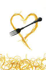 Swirls of cooked spaghetti with fork. Spaghetti heart shape.