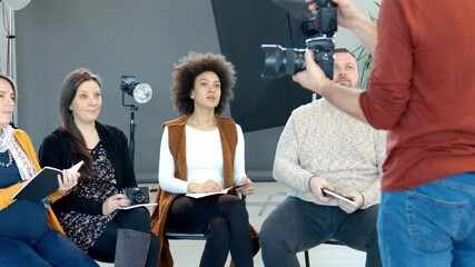 Attendees taking photography lessons from an experienced photographer in the studio.	