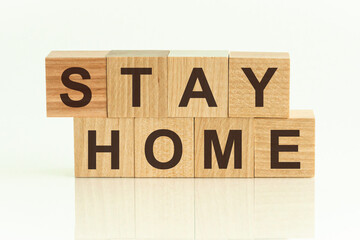 Stay Home - text on wooden cubes on a white gradient background.
