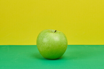 Apple on a green and yellow background. Health concept.