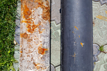 a large metal rusty pipe lies on concrete