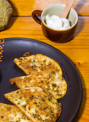 Vegetarian food - celery tuber slices fried in batter in a ceramic plate on a wooden table, close up
