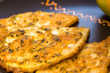 Vegetarian food - celery tuber slices fried in batter in a ceramic plate on a wooden table, close up