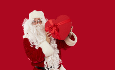 Happy Santa Claus holding boxes with gifts on a red background