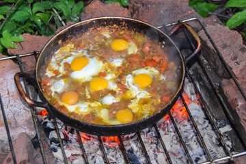 scrambled eggs on a campfire camping in the nature Shakshouka national cuisine