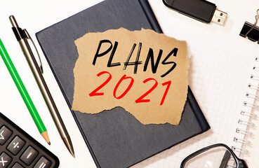 Plan 2021 words written in an office notebook. Concept in business.