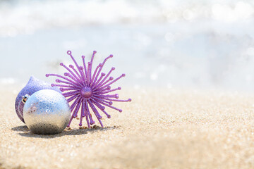 Merry Christmas and Happy New Year background, Christmas glitter pink decoration star on the tropical beach near ocean, a summer Christmas and winter holyday concept, selective focus