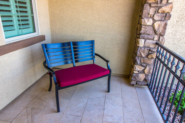 Front Porch Of Home With Metal Bench For Two With Cushion