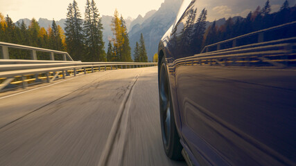 CLOSE UP: Brand new blue car speeds down scenic switchback road in Tre Cime