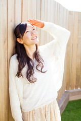 壁にもたれている女性