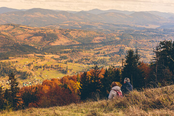 Fototapeta na wymiar Tourists walk and relax, against the backdrop of autumn mountains