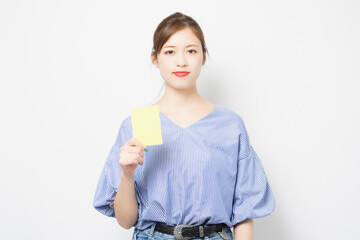 イエローカードを手に持つ若い女性