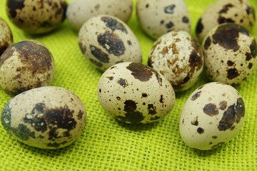Fototapeta premium Quail eggs on a green cloth. Close-up view