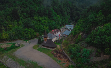 Aerial view of vodita monastery in Romania on a cloudy dull morning, monastery hiding in thick...