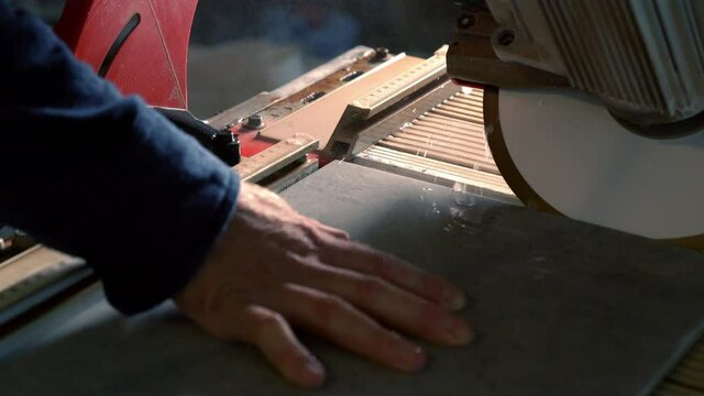Hands of a workman cutting a bevel on a tile