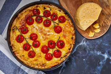 Appetizing pie with baked tomatoes on a branch and chicken