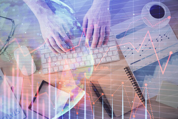 Multi exposure of man's hands typing over computer keyboard and forex graph hologram drawing. Top view. Financial markets concept.