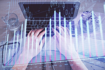 Naklejka premium Multi exposure of man's hands typing over computer keyboard and forex graph hologram drawing. Top view. Financial markets concept.