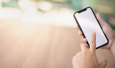 Female hand holding smartphone for find something on internet or shopping online while sitting one person for one table in the Co-working space