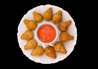 Coxinhas pequenas em prato branco redondo com molho rosê  