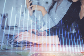 Multi exposure of woman hands typing on computer and financial graph hologram drawing. Stock market analysis concept.