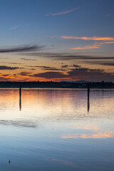 Clouds, reflections and sunrise over the bay