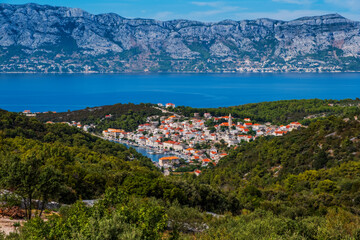 Fototapeta premium POVLJA, CROATIA - August 2020: Beautiful village Povlja on island Brac with mountain Mosor in background. Panoramic view.