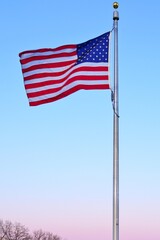 American flag of the United States of America  floating in the sky on a mast