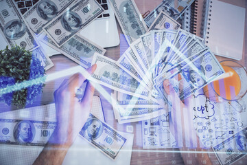 Multi exposure of financial graph drawing hologram and USA dollars bills and man hands. Analysis...