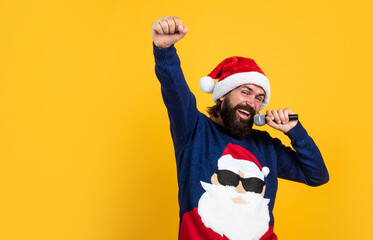 Be positive. xmas shopping time. prepare gifts and presents. karaoke. happy bearded man in santa claus hat sing in microphone. new year party. celebrate winter holidays. christmas songs