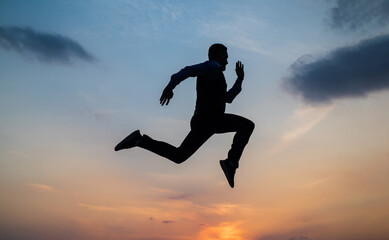 Fototapeta na wymiar Find your freedom. personal achievement goal. man silhouette jump on sky background. confident businessman running. daily motivation. enjoying life and nature. business success. freedom