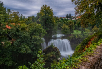 Fototapeta na wymiar Waterfall Veliki Buk - Big Buk in green nature of Korana river, village of Rastoke, Slunj, Croatia. August 2020. Long exposure picture.