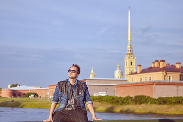 Obraz premium Young hipster sits in historic center of Saint-Petersburg, Russia.