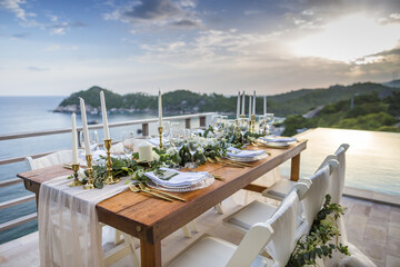 Romantic Wedding Table Top Layout Table Spread no people tropical location with gold cutlery and scenic view of sunset with copy space