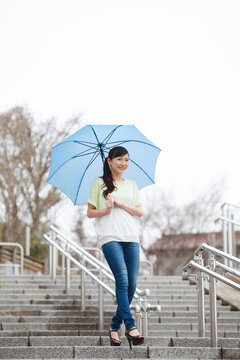 傘をさして階段を降りる女性
