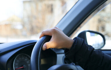 a man driving a car with one hand