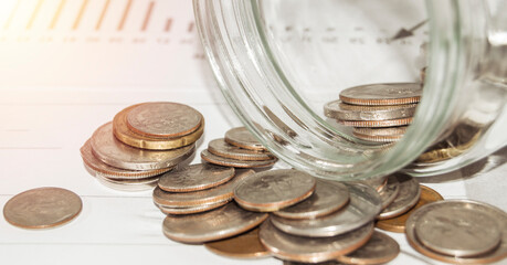 Close-up of Euro coins in a glass jar, scattered on the table, the concept of saving and investing