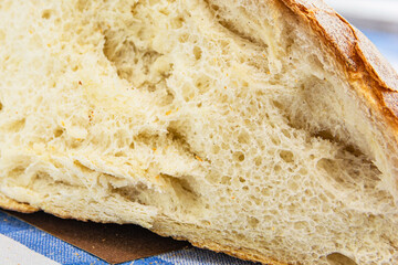 A slice of fresh white crunchy bread lies on the surface. Close-up