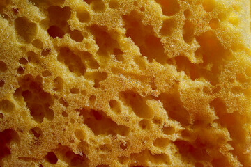 Yellow porous sponge texture closeup