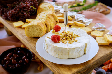 Brie cheese with nuts, bread and grapes.