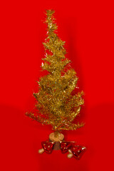 Golden Christmas tree on a red background with red and yellow toadstools
