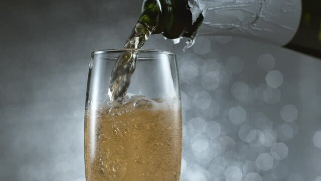 sparkling wine being poured from a bottle into a glass
