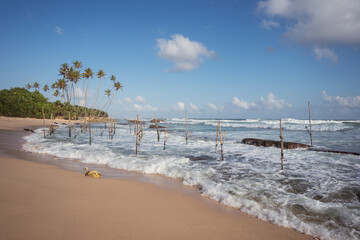 Beautiful landscape of beach in Sri Lanka with traditional fishing sticks on the water