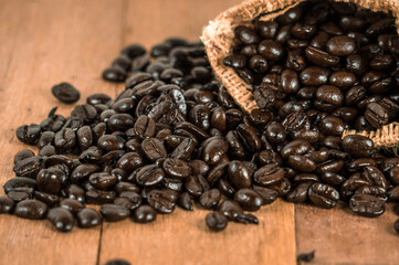 Roasted coffee beans placed on an old wooden table.