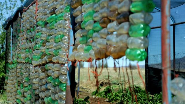 pan shot of recycled plastic bottles used as a wind breaker