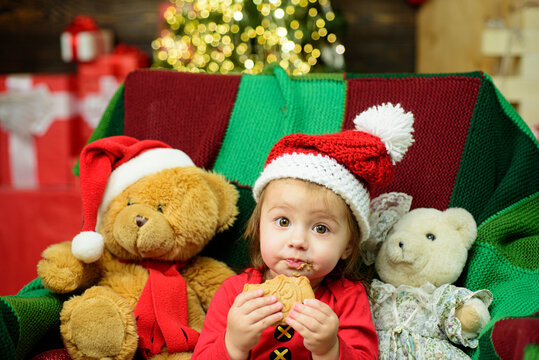 Portrait of funny baby in Santa clothes and Christmas hat.