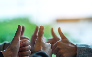 A group of people making thumb up hands sign in circle