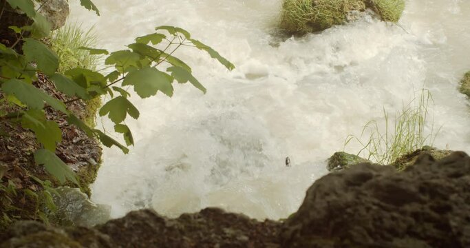 Close up beautiful small rushing waterfall at flowing Eisbach river in the Englischer Garten on a german spring day, Munich, Side view Slow motion